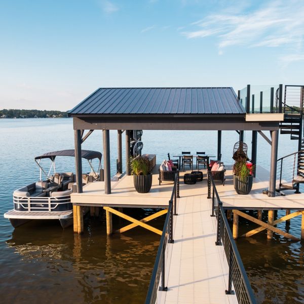 A view of the Trex dock in the color Salt Flat with a boat docked by the dock.